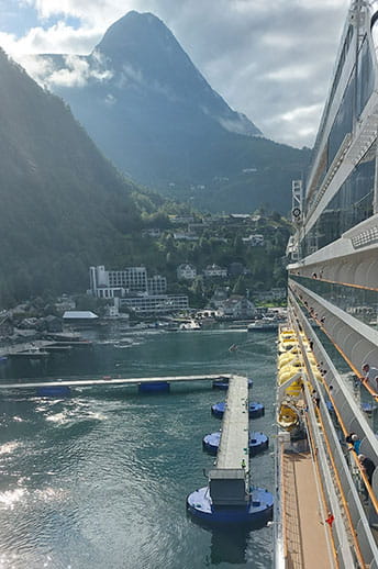 Spirit of Discovery docked in Geiranger, Norway, with a view of the mountains